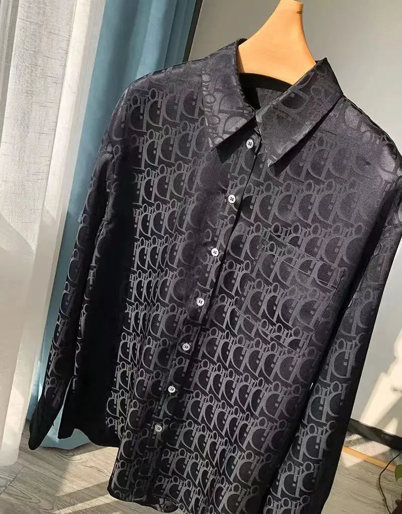 Black patterned shirt on a hanger with a blurred background