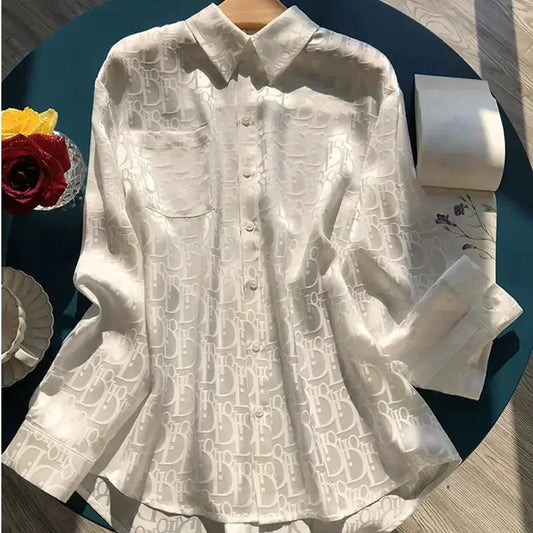 White shirt with lace detailing on a dark surface with decorative items.