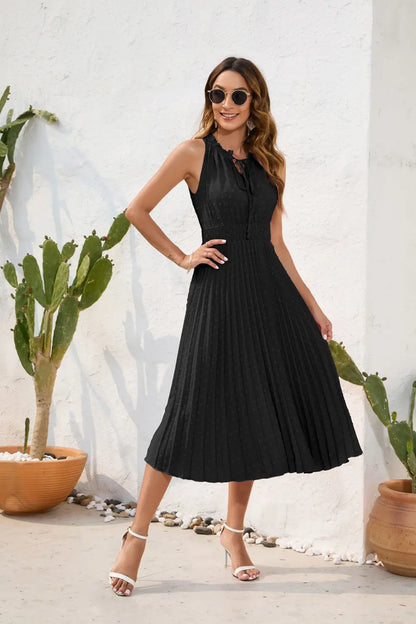 Woman in a black dress standing outdoors with cacti in the background