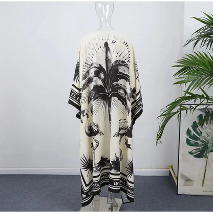 Black and white palm leaf patterned kimono on a mannequin against a white wall with a plant in the corner.