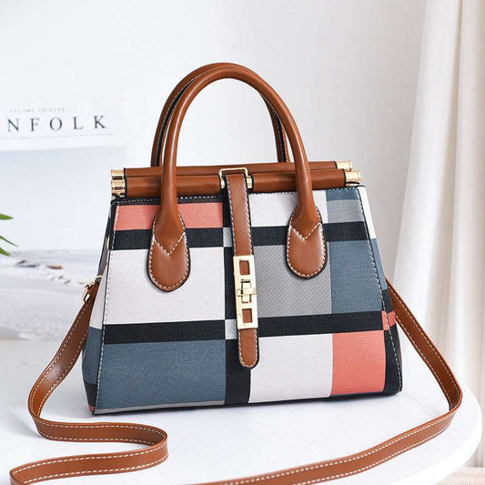 women's handbag Colorful checkered handbag with brown handles and strap on a light background