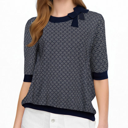 Person wearing a patterned sweater with navy accents on a white background